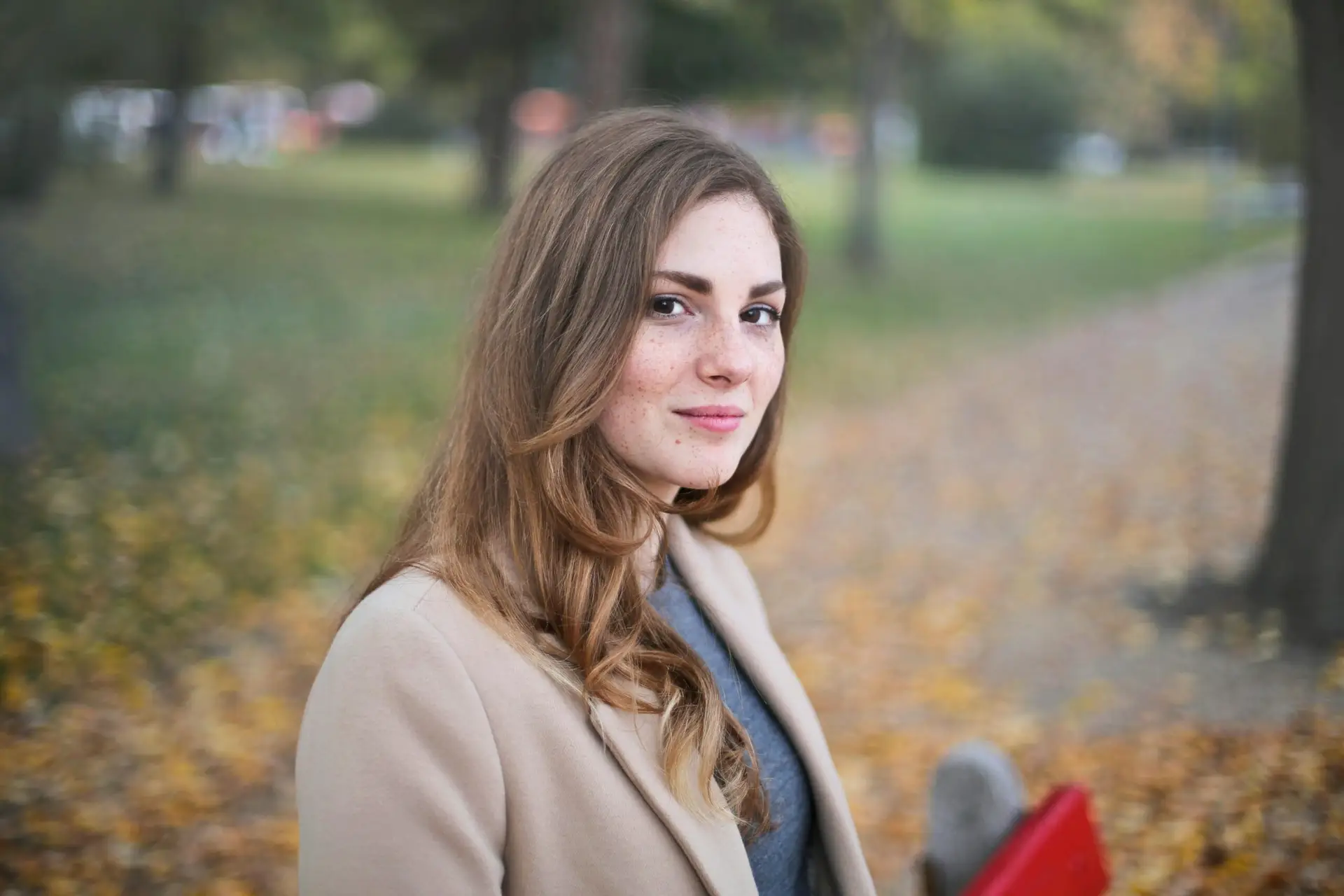 A woman smiles in an autumn setting in Budapest, Hungary.